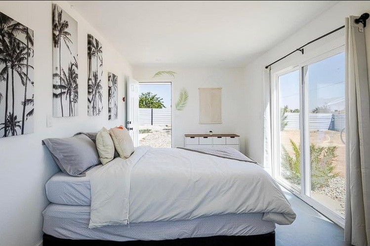 Embrace tranquility in our master bedroom, where full glass windows frame nature's beauty, blurring the line between indoors and the scenic outdoors at Nektar Healing Retreat Los Angeles California