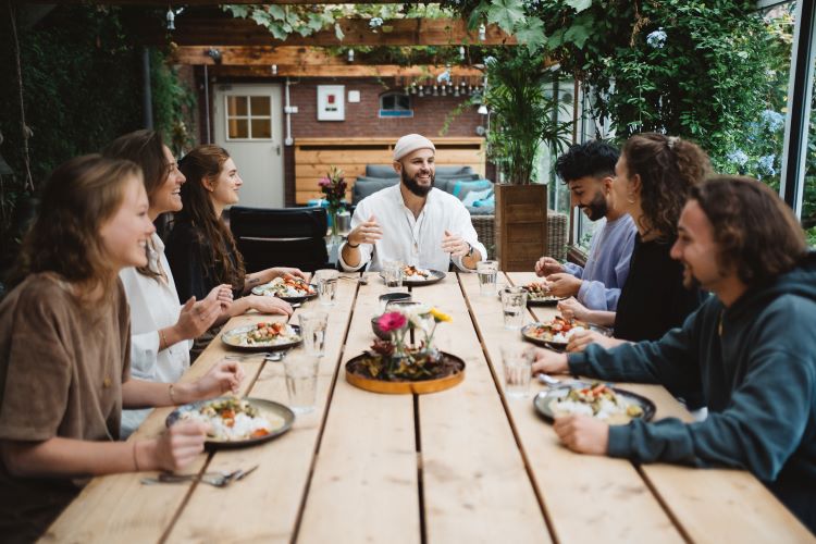 Shared laughter and delectable flavors fill the air in our dining haven. A happy group coming together, turning meals into memories at New Eleusis Psilocybin Retreat Zeeveld The Netherlands