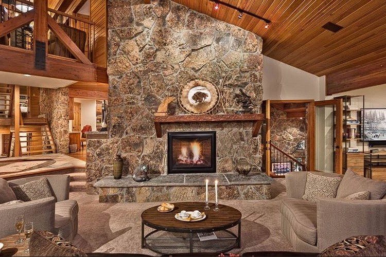 Indulge in the lap of luxury and cozy elegance in our exquisite living room. The warm embrace of the flickering chimney fire casts a golden glow upon opulent furnishings, creating a haven of comfort and style here at Women's Psychedelic Wellness Retreat in Steamboat Springs, Colorado