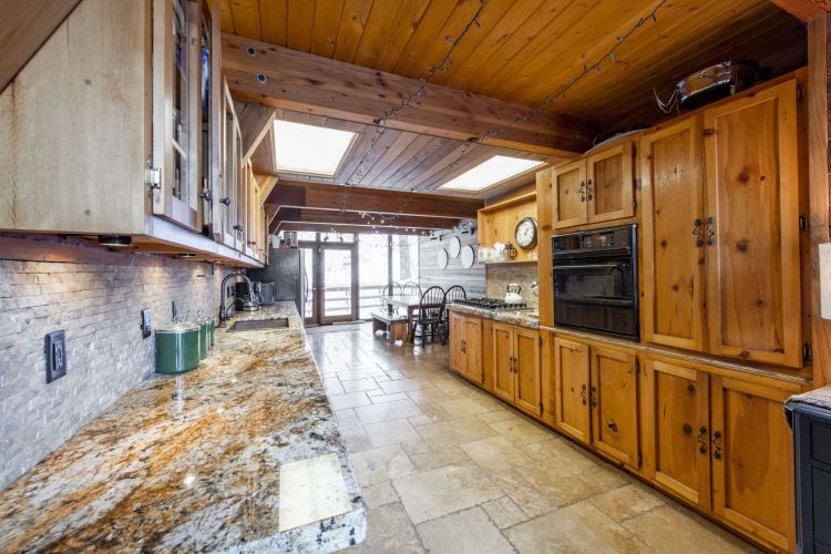 Savor the taste of opulence in this luxury kitchen and dining room, where rich wood accents meet gourmet delights. A feast for the senses in every way here at Healing Through Psychedelic Retreat in Park City Utah, USA