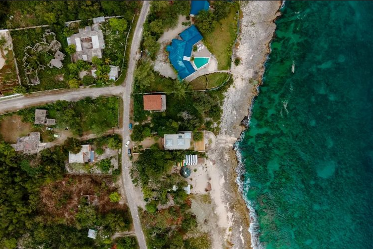 A symphony of blue hues from sky to sea. This aerial glimpse unveils our beachfront retreat, where the dance of waves mirrors the rhythm of rejuvenation. Join us in this coastal sanctuary, where every moment is an elevated experience in tranquility here at ONE Retreats Psilocybin Retreats in West End, Negril, Jamaica.