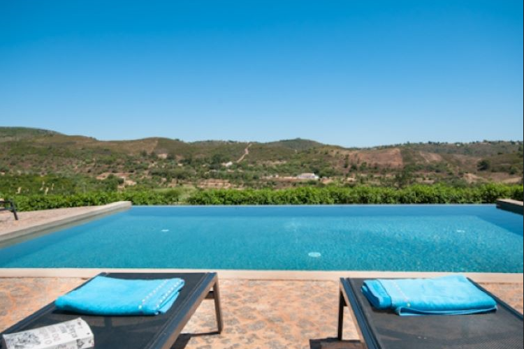Where tranquil waters meet majestic mountains: A serene poolside oasis embraced by nature's grandeur here at Intuitive Kasham Psilocybin Retreat in Faro, Portugal.