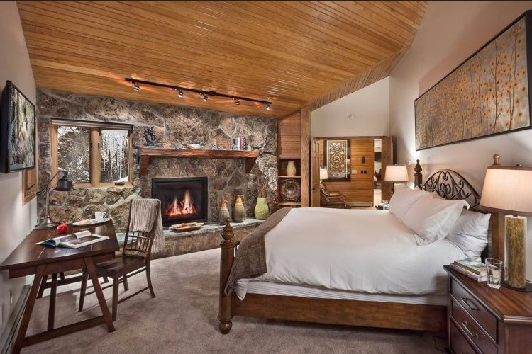 Cozy Elegance: A Bedroom Oasis with a Moss Rock Gas Fireplace, Where Warmth and Nature Embrace in Harmony