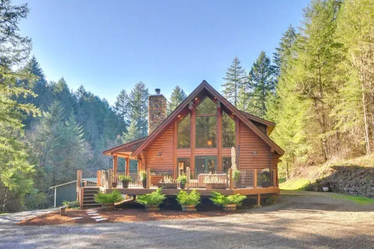 Sanctuary of Serenity: A breathtaking retreat in a stunning custom cedar log home, nestled within 30 acres of nature's embrace. The heart of this haven is a two-story vaulted great room, bathed in natural light from soaring windows and anchored by a unique stone fireplace, inviting warmth and reflection.