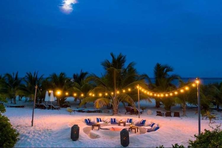 Illuminated by starlight and candles, a magical circle by the beach sets the stage for an enchanting night ceremony, where the sea whispers secrets of renewal and connection.